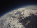 A view looking down on a cloud formation with the balloon near the peak of its flight.