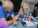 Stan Pozerski, KD1LE, coaches Mia H. in the fine art of sending Morse code. [Ralph Swick, KD1SM, photo]