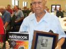 Victor Poor, W5SMM, holding the ARRL President’s Award and a hardbound copy of The ARRL Handbook signed by the ARRL staff. The award was presented recently by Eric Smitt, K9ES. [Dan Fisher, AI4GK, Photo]