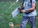 Ready to “punch in” at the finish line of the 2 meter event at last year’s USA ARDF Championships is Brian DeYoung, K4BRI, of Alexandria, Kentucky. He mounted his map board to the elements of his measuring-tape RDF Yagi. [Joe Moell, K0OV, Photo]